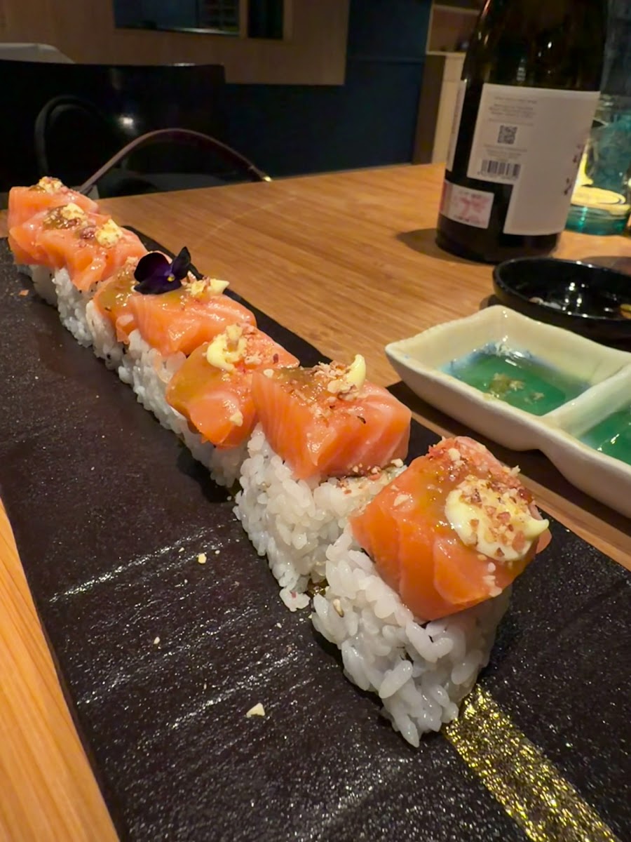 Rollo de salmón servido sobre pizarra negra